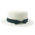 Close-up of the woven straw texture and elegant black ribbon bow on this flat top boater hat - Off White