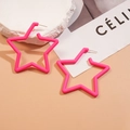Dettaglio di orecchini a stella in acrilico rosa su superficie beige con sassi decorativi - Rosa