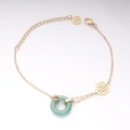 Detail eines Vintage-Goldarmbands mit grünem Jade-Anhänger und Fu-Schmuckstücken - Gold