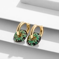 Details von goldenen Emaille-Ohrringen mit grünen Blumenmustern auf Schwarz - Schwarzer Hintergrund Vintage Grünes Rankenmuster
