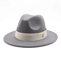 Detailed texture of grey wool fedora with beige decorative ribbon and gold M logo - Light Gray