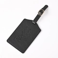 Detail shot of black PU leather luggage tag with Adventure Begins embossed text and metal buckle - Black