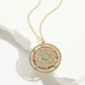 Detailed view of vintage gold compass pendant with red and green enamel on white stone - Vintage Enamel Compass