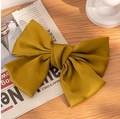 Large yellow satin bow hair clip accessory placed on a wooden surface with soft lighting - Yellow Satin Large Bow