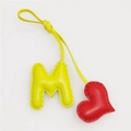 Detail showing hand-stitched leather letter M and heart charm with lychee texture - Red Heart and Light Yellow M