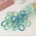 Detalle de gomas de pelo sin costuras en verde menta y azul marino en frasco de vidrio - Green System