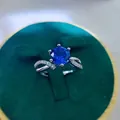 Macro shot of a silver ring with a 2-carat red ruby in a green velvet jewelry gift box - A10 Open Type / Blue