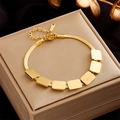 Detail of adjustable gold snake chain bracelet with seven rectangular charms on a jewelry box - Rectangle Plate Snake Bone Chain (B737) / Gold