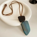 Détail du pendentif irrégulier en résine verte et bois sur collier en cuir marron - Collier-Marron-Bleu