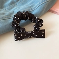 Detailed view of a black and white polka dot bow scrunchie on blue denim fabric - Black White Polka Dot
