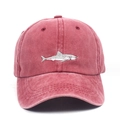 Close-up of vintage washed red baseball cap featuring detailed shark embroidery and stitching - One Size / Burgundy