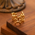 Adjustable matte gold open ring with olive leaf vine design on dark wooden surface - Olive Branch Wrap / Gold