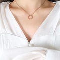 Twisted rope circle necklace in rose gold finish worn on model with elegant white top - Rose Gold Necklace