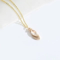 Collana dorata con ciondolo a foglia e zircone trasparente su sfondo in tessuto bianco - Zirconia Bianca (XL3206)
