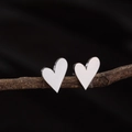 Orecchini a lobo minimalisti a cuore in argento su sfondo di ramo rustico - Color Acciaio