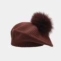 Close-up of wine red knitted beret with a fluffy faux fox fur pompom detail - Brown