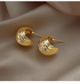 Close-up of hammered gold crescent stud earrings resting on elegant champagne silk fabric - Gold Hammered Crescent Style (E002)