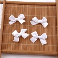 Set of four handmade white satin ribbon bow hair clips on natural bamboo mat background - Pure White