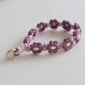 Detailed macro of hand-woven lavender daisy flower lanyard with gold spring clasp - Vintage Purple