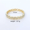 Gold elastic bracelet featuring smiley face charms with blue rhinestone eyes - Blue