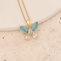 Close-up of golden butterfly pendant with blue and white stones on textured stone - Exquisite Butterfly Shape Style (11#)