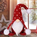 Gnomo di Natale con cappello rosso a maglia e motivi a cuore su un tavolo di legno - Rosso