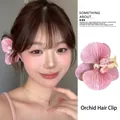 Pink orchid hair clip with gradient petals and pearl detail worn by a model - Pink Butterfly Orchid