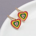 Macro detail of gold hoop earrings with colorful layered enamel heart pendants and crystals - Yellow