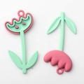 Macro shot of colorful tulip charms in matte pink and green finish for DIY jewelry - Red