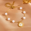 Golden stainless steel pearl bracelet with floral pendant on silk background - White Shell Clover Pearl Bracelet