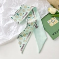 Mint green silk twilly scarf with lemon pattern and lemonade slogan laid on white paper - Letter Lemon