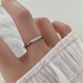 Detailaufnahme eines silbernen minimalistischen Rings mit flacher Oberseite und B'aime-Gravur - US 6 / Stahlfarbe