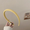 Détail d'un serre-tête en tissu jaune avec texture fine et étiquette faite à la main - Jaune