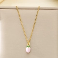 Détail d'un pendentif fraise rose sur une chaîne dorée sur fond de tissu beige - Fraise Rose (KN292089-Z)