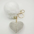 Detailed view of fluffy white pompom keychain with sparkling crystal heart pendant - White