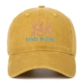 Macro shot of fine embroidery featuring a female silhouette and text on a cotton baseball cap - Yellow
