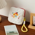Détail d'une broderie de chiot sur une trousse de maquillage blanche matelassée - Chien Fraise