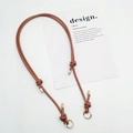 Detail of adjustable brown leather bag strap with gold metal ring and decorative knot - Gold Ring Buckle / Tan
