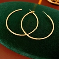 Dettaglio macro di orecchini a bottone dorati tondi con finitura opaca satinata - Ago in Argento - Oro (Placcato Oro Vero)