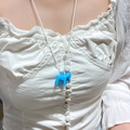 Dettaglio della collana con pendente a cavallo blu reale su modella in camicia bianca - Pony Blu Lago (4113)