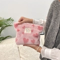 Close-up of plush pink vanity bag with red heart pattern held in hand for detail - Pink with Red Hearts