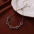 Detail view of silver adjustable bracelet featuring five oval blue stones on satin - Silver Tone Blue Oval Adjustable Slider Style