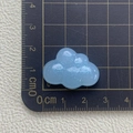 Nahaufnahme eines blauen Wolken-Accessoires aus Harz mit Glitzer auf einer Schneidematte - Blau glitzernde Wolke