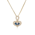 Detailed close-up of a gold heart pendant with clear diamonds and blue gemstones - Blue Pear Stone Heart
