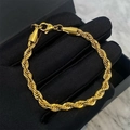 Polished 18k gold plated twist rope chain bracelet with lobster clasp on display - 19【e27】5mm Braided Bracelet Gold