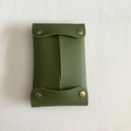 Close-up of green lychee pattern leather tissue pouch with bronze metal snaps - Green