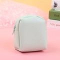Close-up of litchi pattern PU leather stitching on a mint green mini coin purse - Green