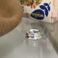 Silver multi-layer wavy open ring with adjustable band shown on a reflective surface - JZ0723 (Multi-Layer Wave)