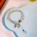 Grey crystal beaded bracelet with lucky cat charm and silver accessories on white tray - Off-White Crystal Peanut Abacus Fortune Cat Bracelet