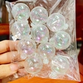 Hand holding a pack of transparent iridescent AB finish sphere cake toppers - Iridescent Transparent Ball Set (S)